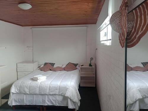 Habitación pequeña con 2 camas y espejo. en En lo de su en Calchaquí