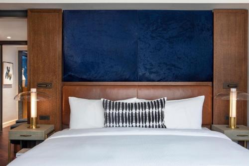 a bedroom with a large bed with a blue headboard at JW Marriott Essex House New York in New York