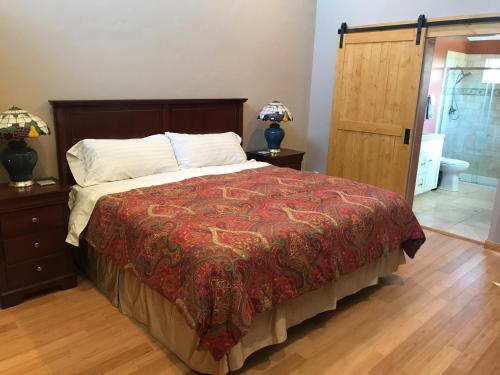 a bedroom with a bed with a red comforter at Morning Star Vista near Yosemite - countryside with mountain views in Mariposa