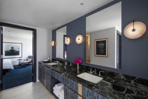 a bathroom with two sinks and two mirrors at JW Marriott Essex House New York in New York