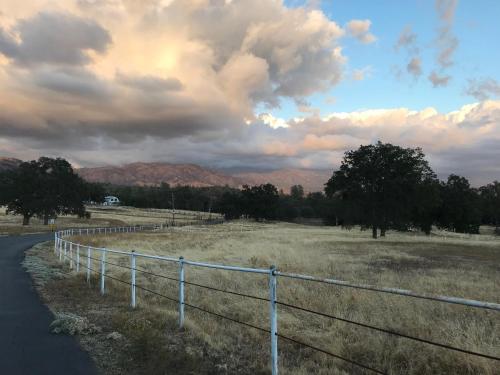 a fence on the side of a road in a field at Morning Star Vista near Yosemite - countryside with mountain views in Mariposa