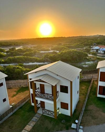 a building with the sunset in the background at Casa 3 Atins in Atins