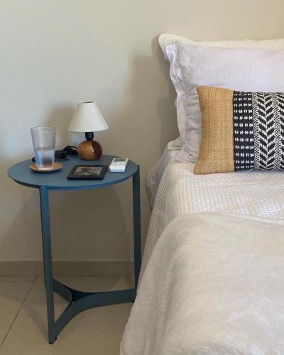 a blue table with a lamp on it next to a bed at Casa 3 Atins in Atins