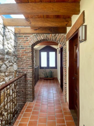 a hallway with a brick wall and a wooden ceiling at La Estancia in San Cristóbal de Las Casas