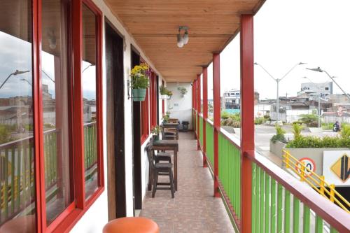 uma varanda de um edifício com tinta vermelha e verde em Hotel Balcón cafetero em Montenegro