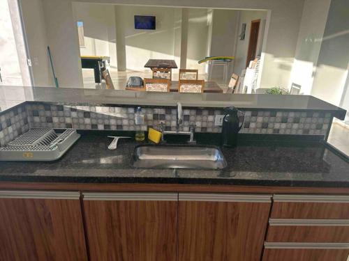 - un comptoir de cuisine avec un évier et un miroir dans l'établissement Chácara Por do Sol, à Serra Negra