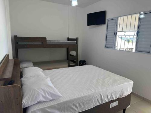 une chambre avec un lit et une télévision dans l'établissement Chácara Por do Sol, à Serra Negra