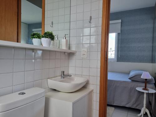 ein Badezimmer mit Waschbecken und Toilette und ein Bett in der Unterkunft Palm Village Acqua Porto de Galinhas por Brevelar in Porto De Galinhas
