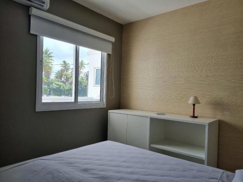 ein Schlafzimmer mit einem Bett und einem Fenster in der Unterkunft Palm Village Acqua Porto de Galinhas por Brevelar in Porto De Galinhas