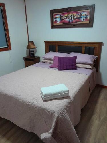 a bedroom with a large bed with two towels on it at Linda y cómoda cabaña en un entorno natural in Los Ángeles