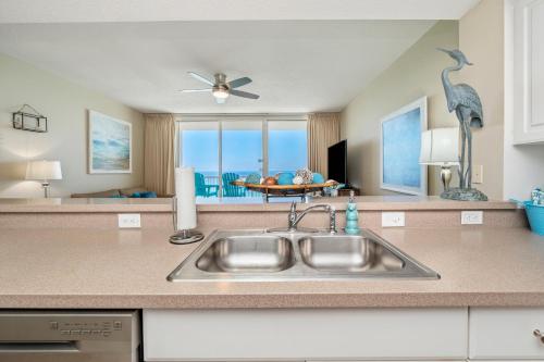 a kitchen with a sink and a view of the ocean at Stunning Ocean & Sunset Views, Direct Beach Access with 2 King Bedrooms at Panama City Beach, Fl in Panama City Beach