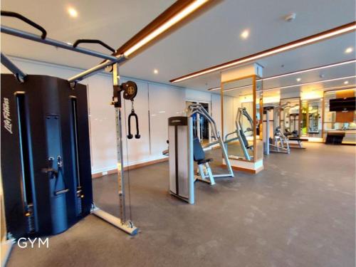 a gym with treadmills and machines in a room at 1BR Prisma Residences DMCI Stylish Condo in Manila