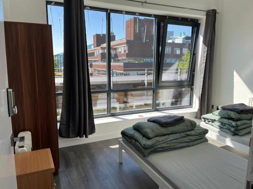 Zimmer mit einem Bett und einem großen Fenster in der Unterkunft Mordern Apartment in City Center in Manchester