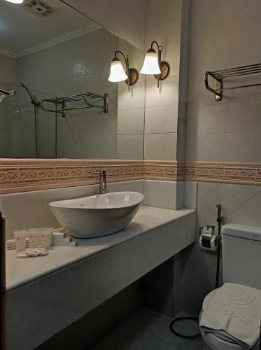 a bathroom with a bowl sink and a mirror at Hotel Salcedo De Vigan in Vigan