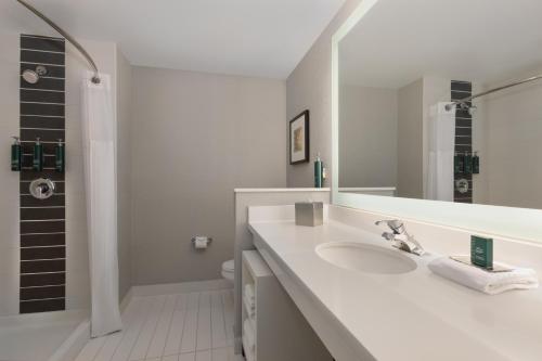 La salle de bains blanche est pourvue d'un lavabo et d'une douche. dans l'établissement DoubleTree by Hilton Las Vegas East Flamingo, à Las Vegas