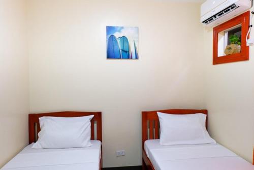 2 Betten nebeneinander in einem Zimmer in der Unterkunft Downtown Suites CDO in Cagayan de Oro
