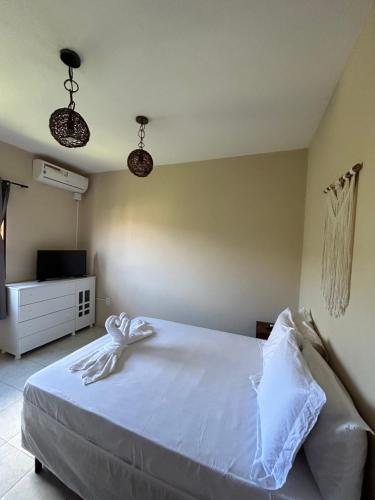 1 dormitorio con cama, TV y luces en Pôr do Sol Suítes, en Lençóis