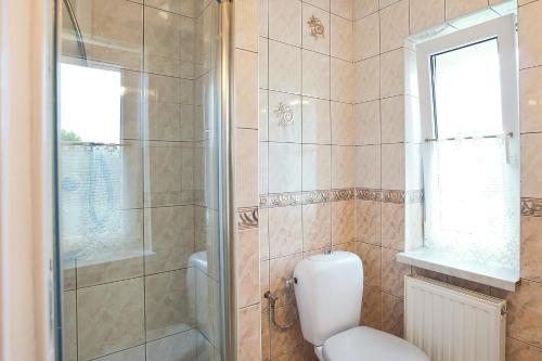 a bathroom with a toilet and a glass shower at Pokoje Gościnne Gazda in Polanica-Zdrój