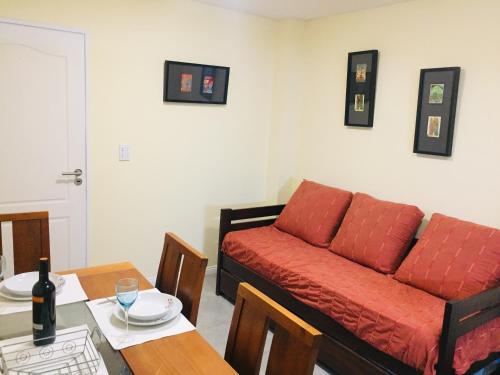 sala de estar con sofá rojo y mesa en Departamento pleno centro de Mendoza con cochera en Mendoza