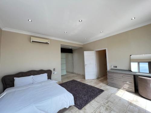 a bedroom with a bed and a sink and a mirror at ZIRICH PROPERTIES EAST LEGON in Accra