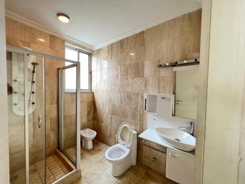 a bathroom with a toilet and a sink and a shower at ZIRICH PROPERTIES EAST LEGON in Accra