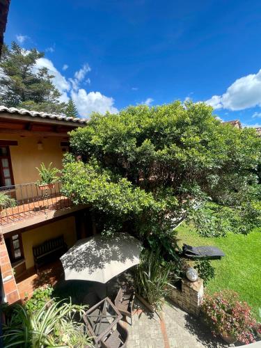 a patio with an umbrella in front of a house at Parador Margarita in San Cristóbal de Las Casas