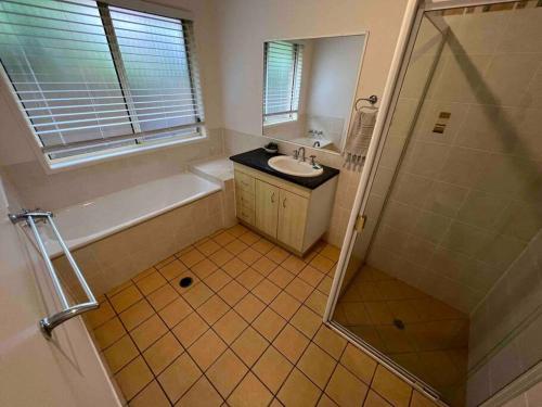 a bathroom with a shower and a sink and a tub at Sandstone Point and Bribie Beaches in Sandstone Point