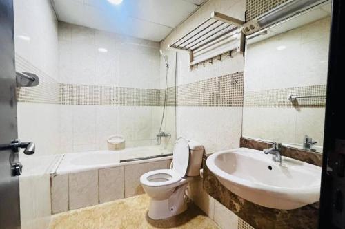 a bathroom with a toilet and a sink and a tub at Loft Style Partition Room in Shared Apartment in Al Barsha 1 Near MOE Metro in Dubai