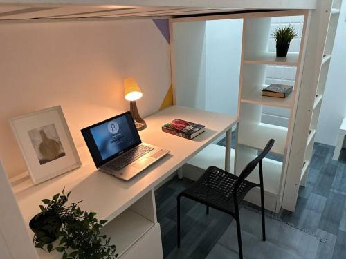 a laptop computer sitting on a desk with a chair at Loft Style Partition Room in Shared Apartment in Al Barsha 1 Near MOE Metro in Dubai