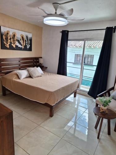 a bedroom with a bed and a large window at Loft atardecer in Uruapan del Progreso