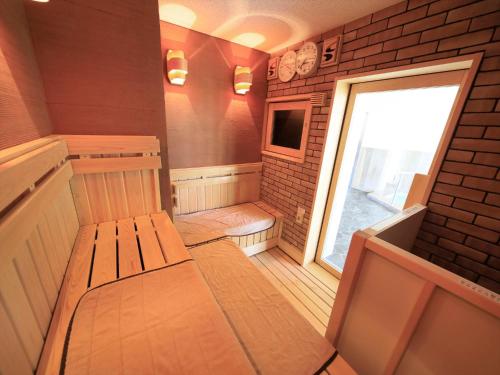 a small sauna with a bench and a window at Hotel Futabanomori 