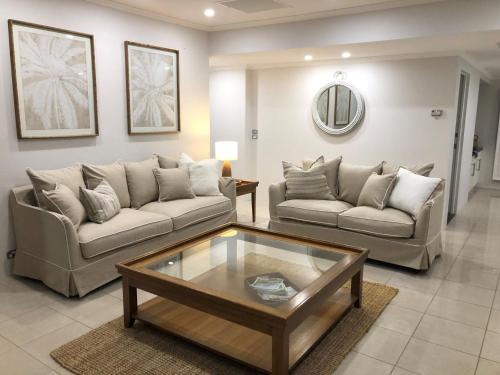 a living room with two couches and a coffee table at Views More Views Sub Penthouse at The Breakwater in Shoal Bay in Shoal Bay