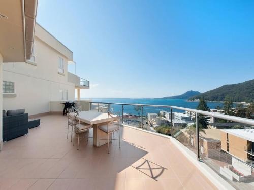 a balcony with a table and chairs and the ocean at Views More Views Sub Penthouse at The Breakwater in Shoal Bay in Shoal Bay