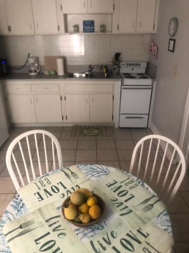 a kitchen with a table with a bowl of fruit on it at Surfside Suites in Cocoa Beach