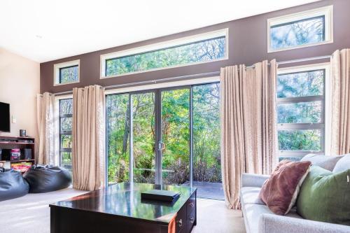 salon z dużymi oknami i kanapą w obiekcie Bush House - Lake Tekapo w mieście Lake Tekapo
