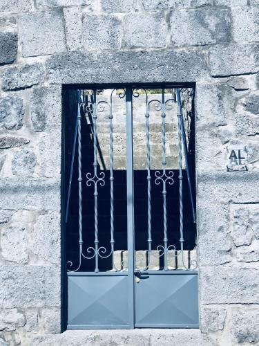 a window in a stone building with a gate at AMU- Apartamentos Mistérios da Urzelina in Urzelina