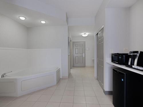 een witte badkamer met een bad en een wastafel bij Holiday Inn Express & Suites Lakeland North I-4, an IHG Hotel in Lakeland