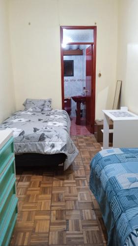 a bedroom with two beds and a wooden floor at Preciosa casa colonial in Quito