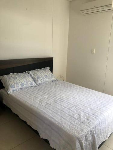 a bedroom with a bed with a white comforter at Apartamento familiar in Sincelejo