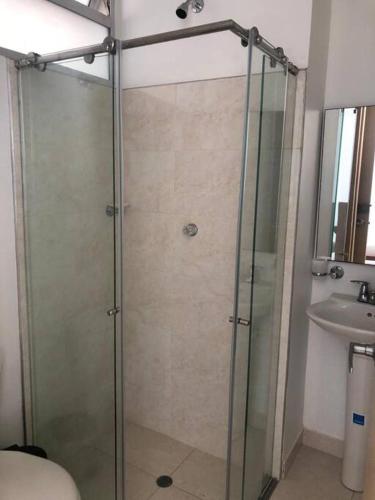a glass shower in a bathroom with a sink at Apartamento familiar in Sincelejo