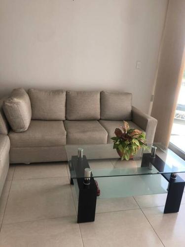 a living room with a couch and a glass coffee table at Apartamento familiar in Sincelejo