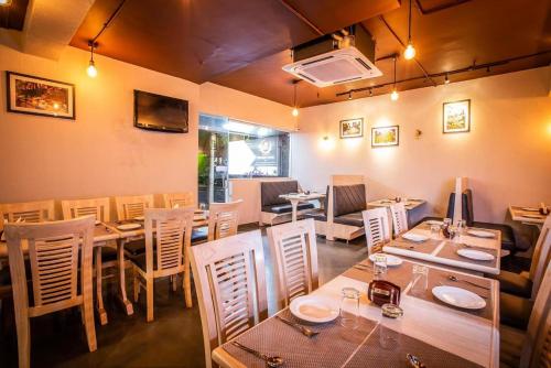a restaurant with tables and chairs in a room at Coastal Pearl Hotel Margao Railway Station in Madgaon