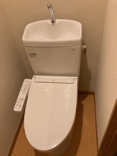 a white toilet with a sink on top of it at Komatsuya Seki Onsen in Myoko