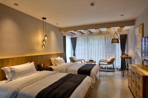 a hotel room with two beds and a television at 张家界惹莲心栖墅·精品民宿 in Zhangjiajie