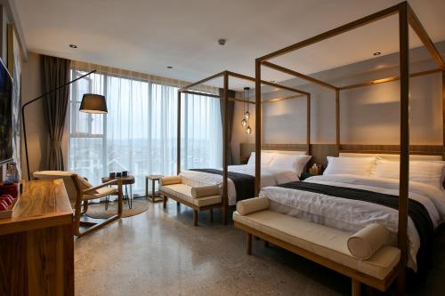 a bedroom with a canopy bed and a living room at 张家界惹莲心栖墅·精品民宿 in Zhangjiajie