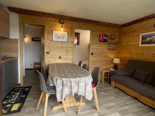 un salon avec une table, des chaises et un canapé dans l'établissement Studio cabine calme avec parking proche commodités - FR-1-505-194, à Notre-Dame-de-Bellecombe