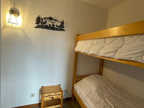 - une chambre avec des lits superposés et une lumière sur le mur dans l'établissement Studio cabine calme avec parking proche commodités - FR-1-505-194, à Notre-Dame-de-Bellecombe
