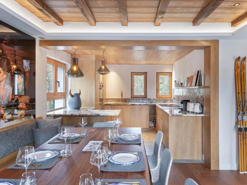 une salle à manger avec tables et chaises et une cuisine dans l'établissement Chalet moderne et spacieux à Megève, 5 chambres, jacuzzi, salle TV, proche centre et remontée mécanique - FR-1-569-119, à Megève