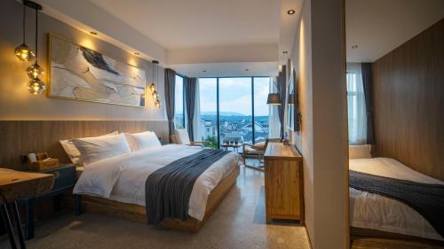 a hotel room with a bed and a window at 张家界惹莲心栖墅·精品民宿 in Zhangjiajie