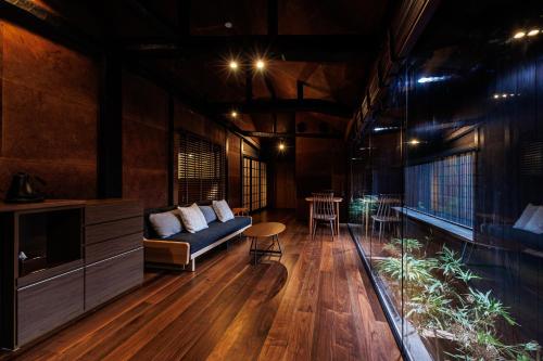 uma sala de estar com um sofá e uma mesa em 浜崎の宿萩別邸 em Hagi